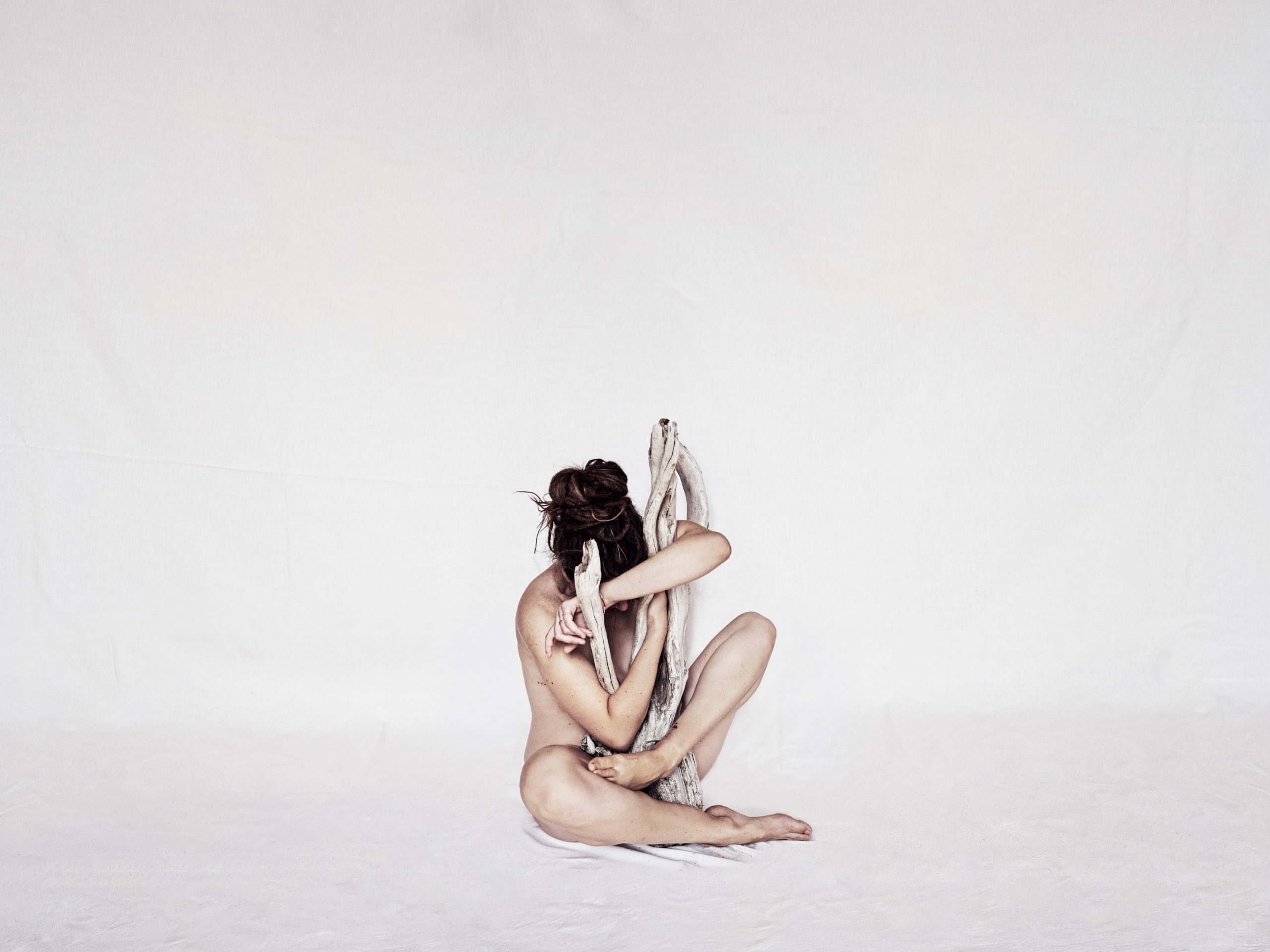 Self portrait of an undressed woman in a white space symbolizing personal growth.