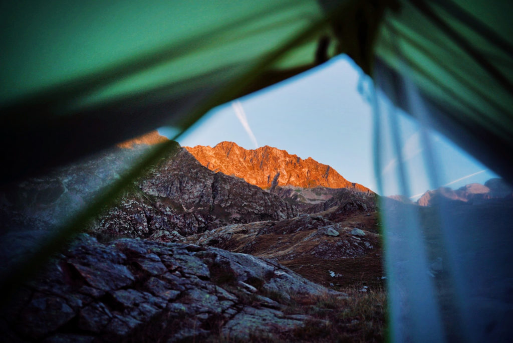 A beautiful sunrise in the mountains as seen from a tent.