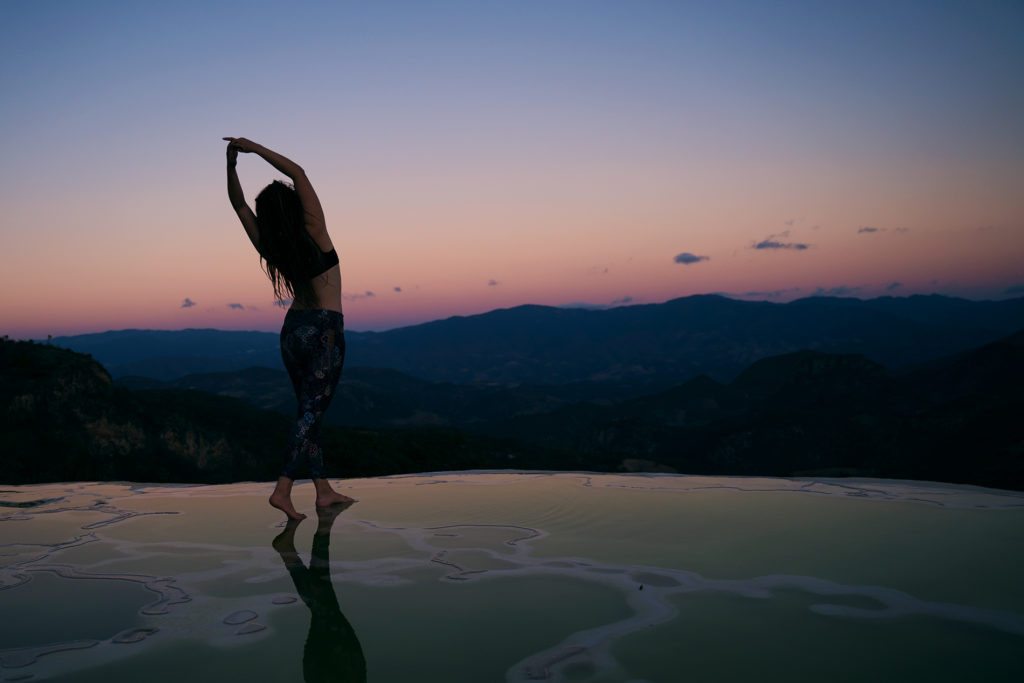 A woman stretching in a beautiful landscape in the evening
