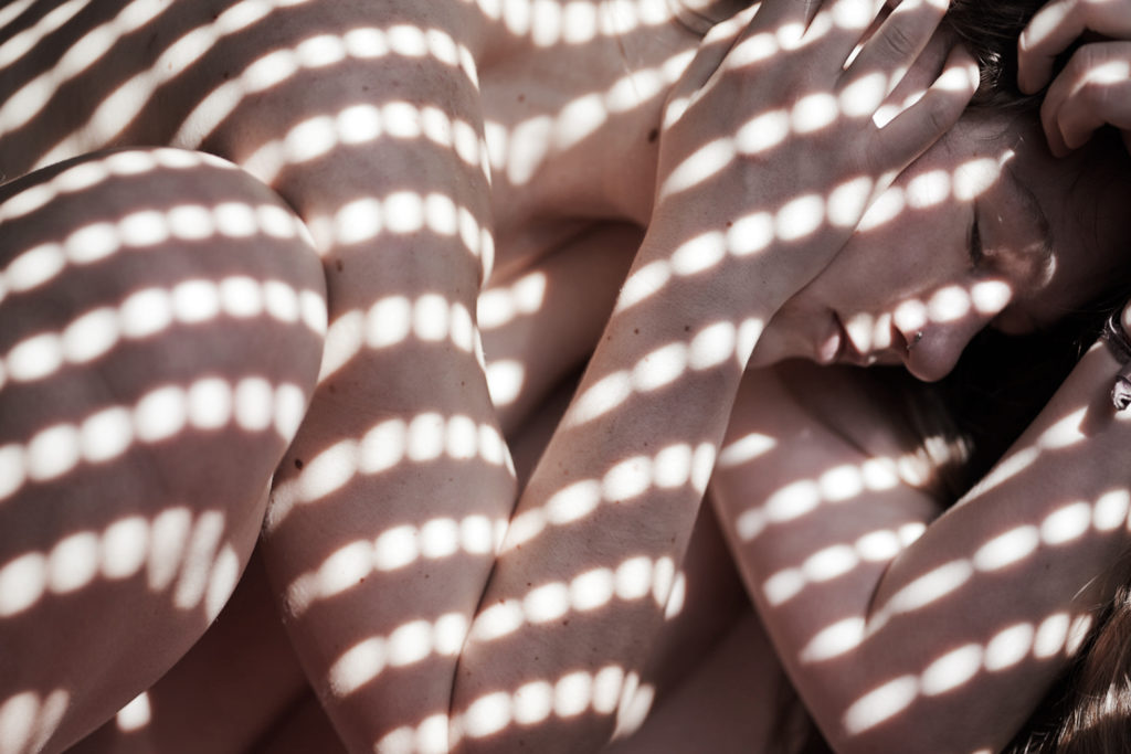 Self portrait of a naked woman covered in light dots