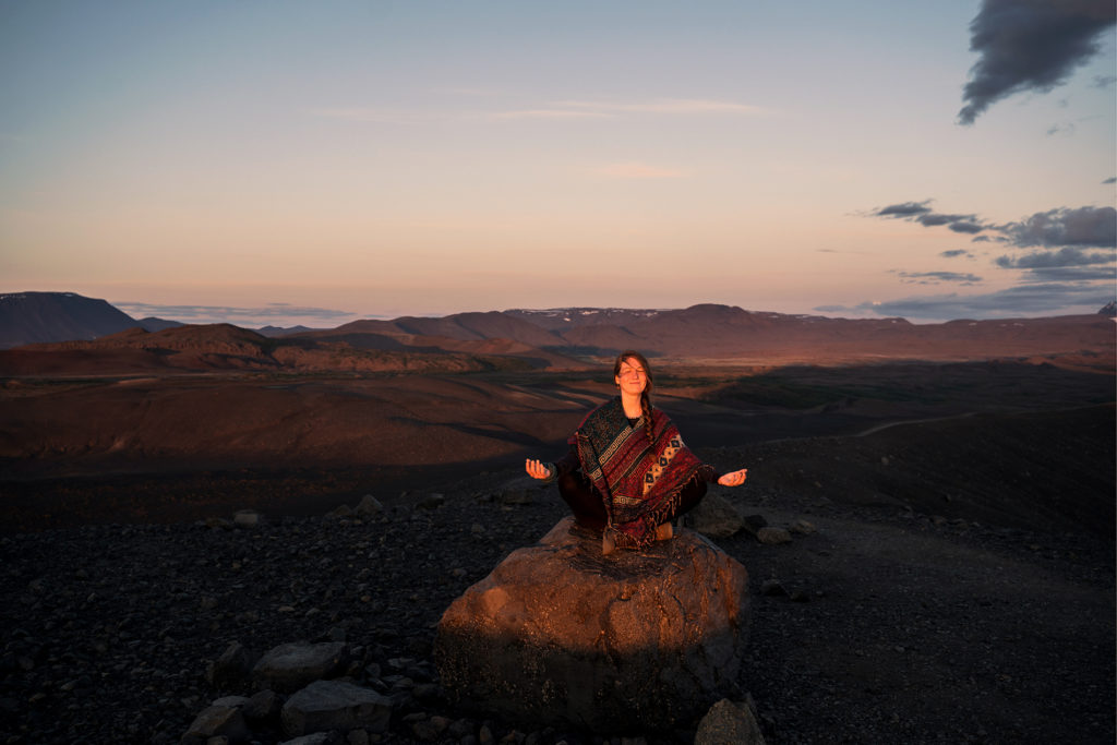 woman meditating on a rock