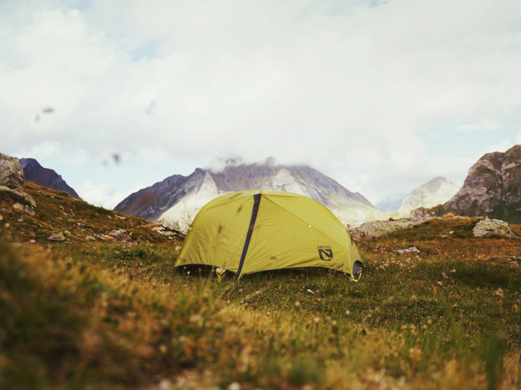 A green tent wild camping in the alps