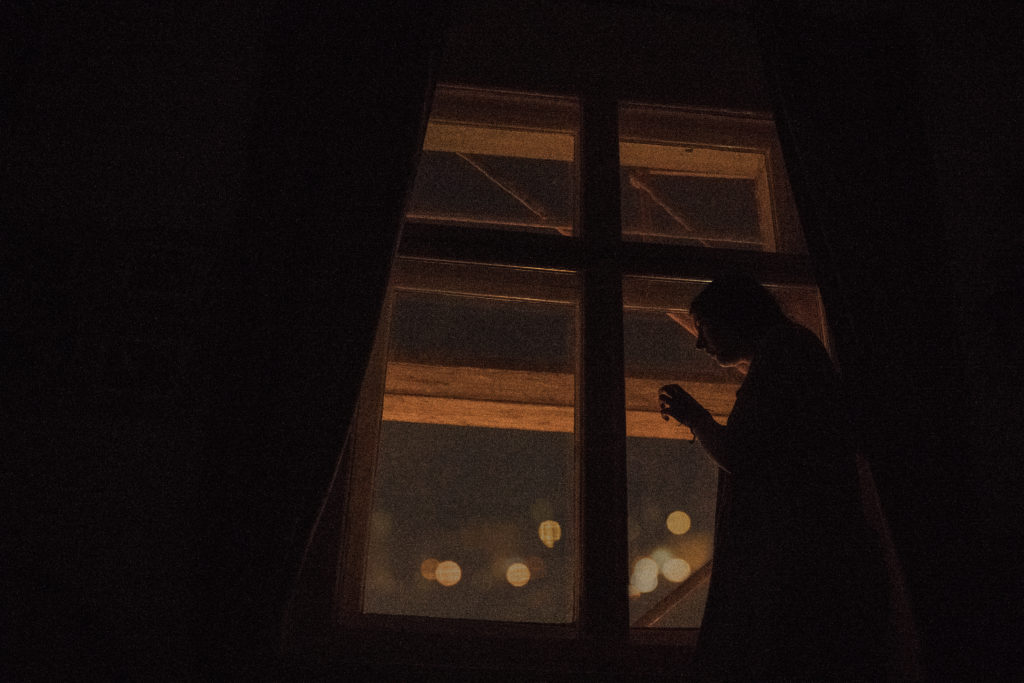 A lonely person looking outside the window