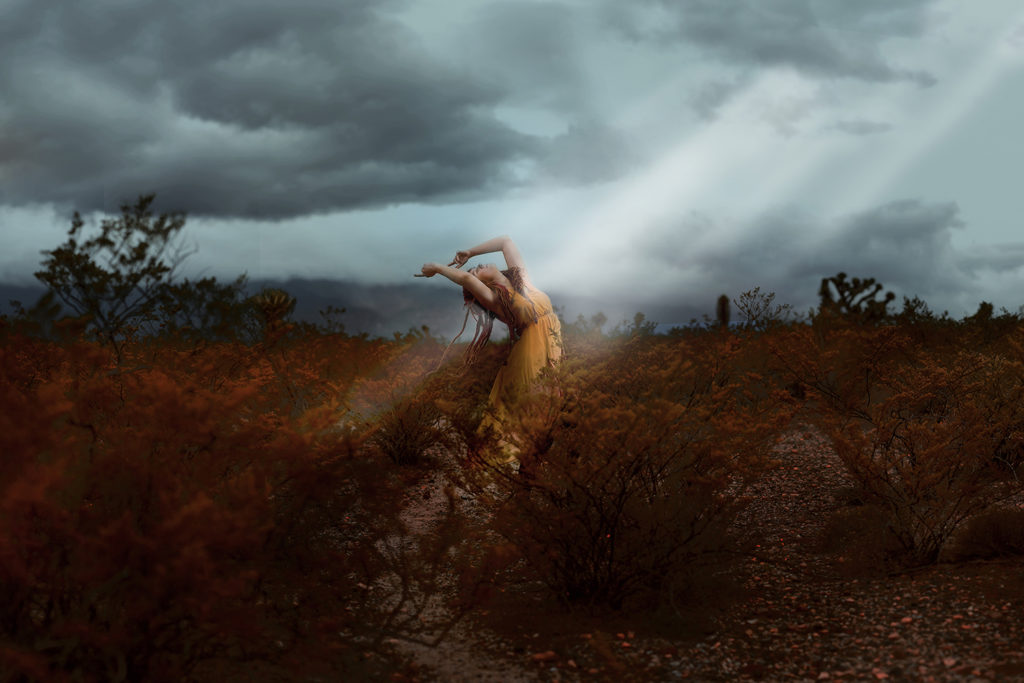 A woman dancing wildly, a light beam hitting her chest.