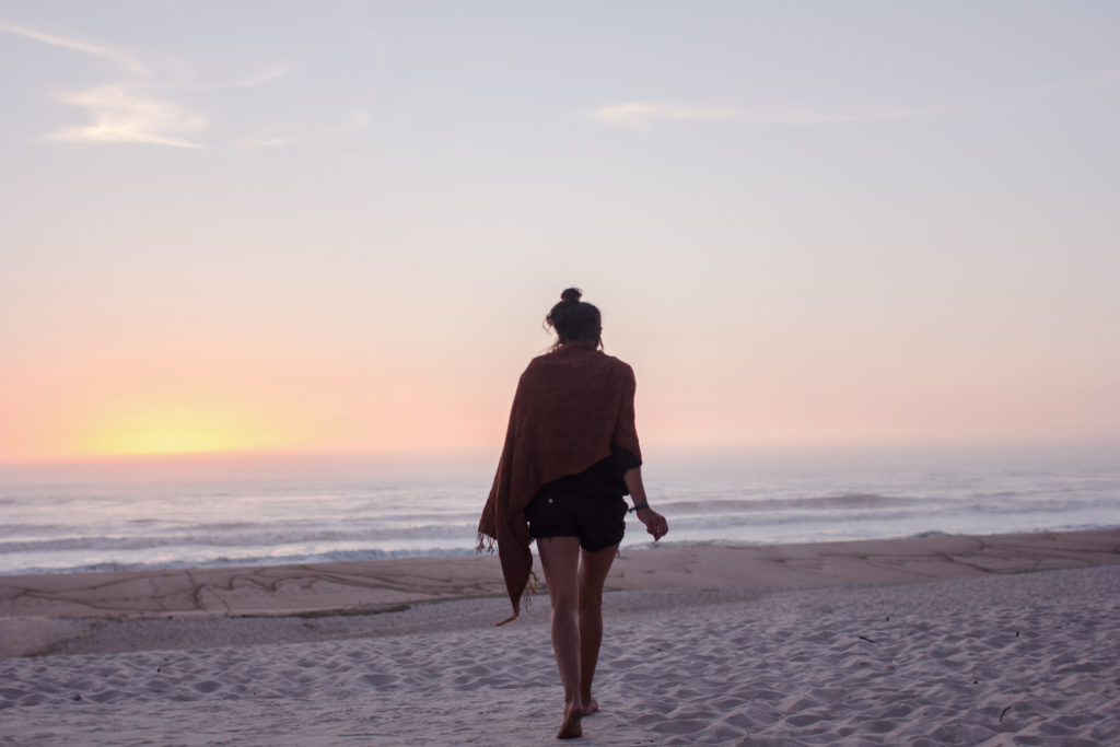 A young woman walking towards the beach.
