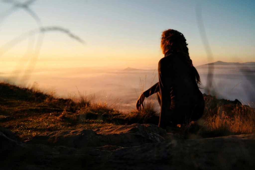 a woman enjoying the sunset on her long distance hike