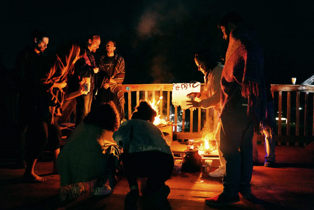 A group of travelers hanging out by a fire.