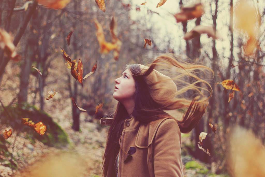 A fine art portrait of a woman surrounded by flying leaves.
