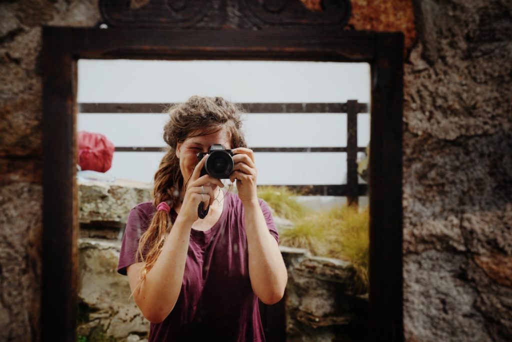 A portrait photographer taking a mirror selfie.