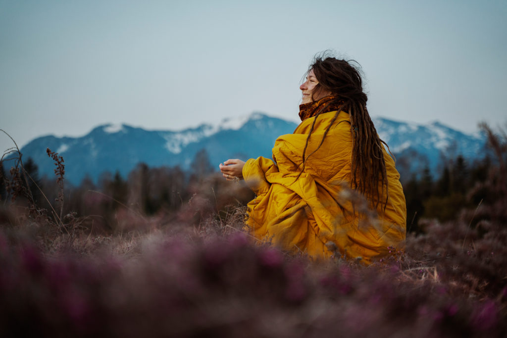 A woman sitting in a meadow after making important life changes.
