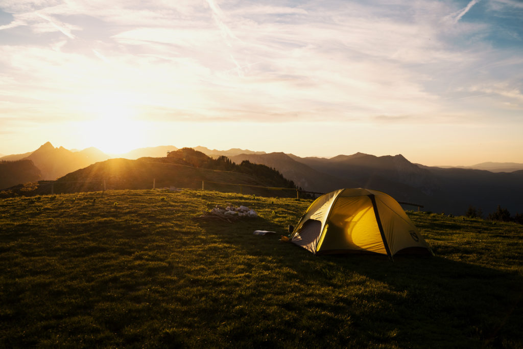 A tent during sunset in the mountains.
