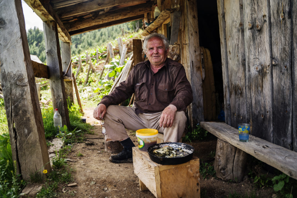 An Albanian man in front of his mountain hut.