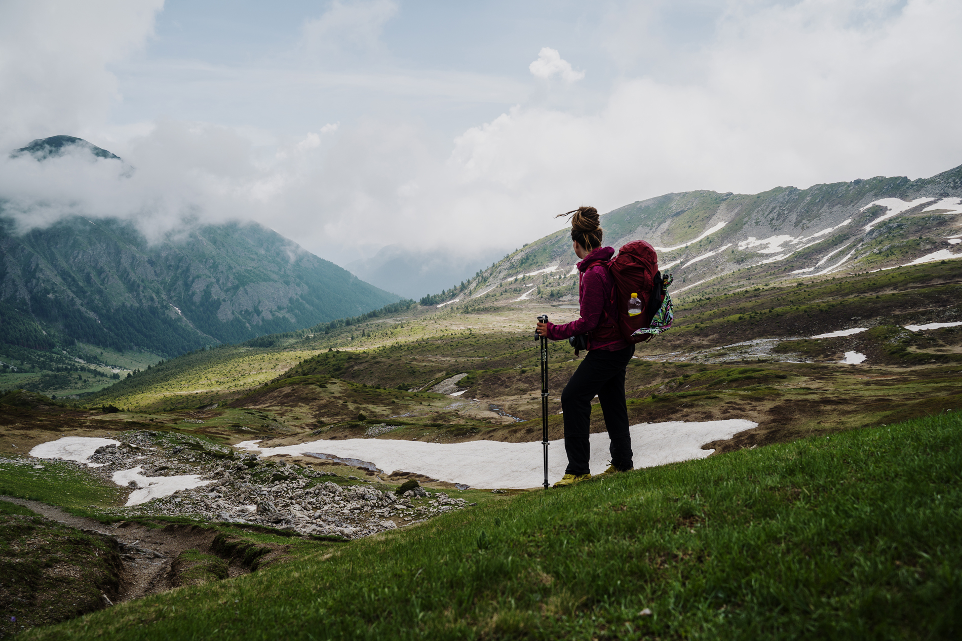 A female solo hiker in the landscapes of the Peaks of the Balkans trail.