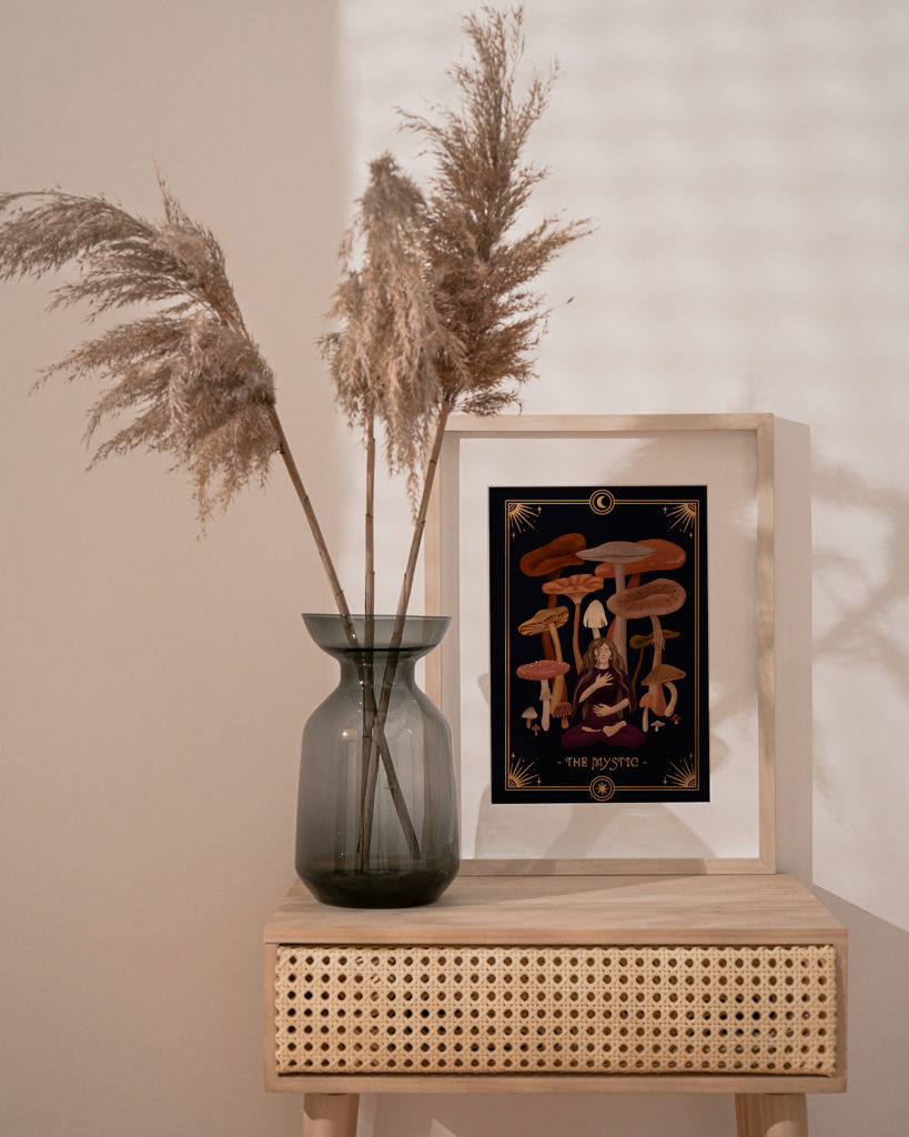 A boho interior with a dried plant in a vase showcasing a fine art print. The artwork shows an illustration of the Mystic Archetype, one of the 7 Feminine Archetypes, with a calm and peaceful aura.