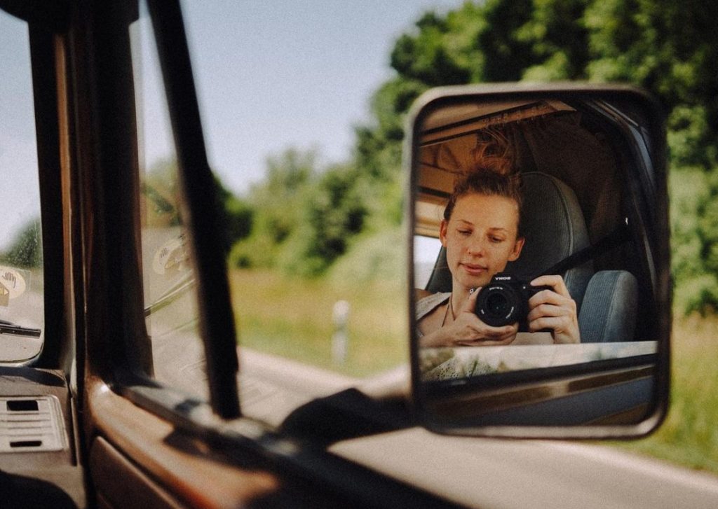 A roadtrip selfie - artist Rona Keller photographs herself in the car mirror during a trip.