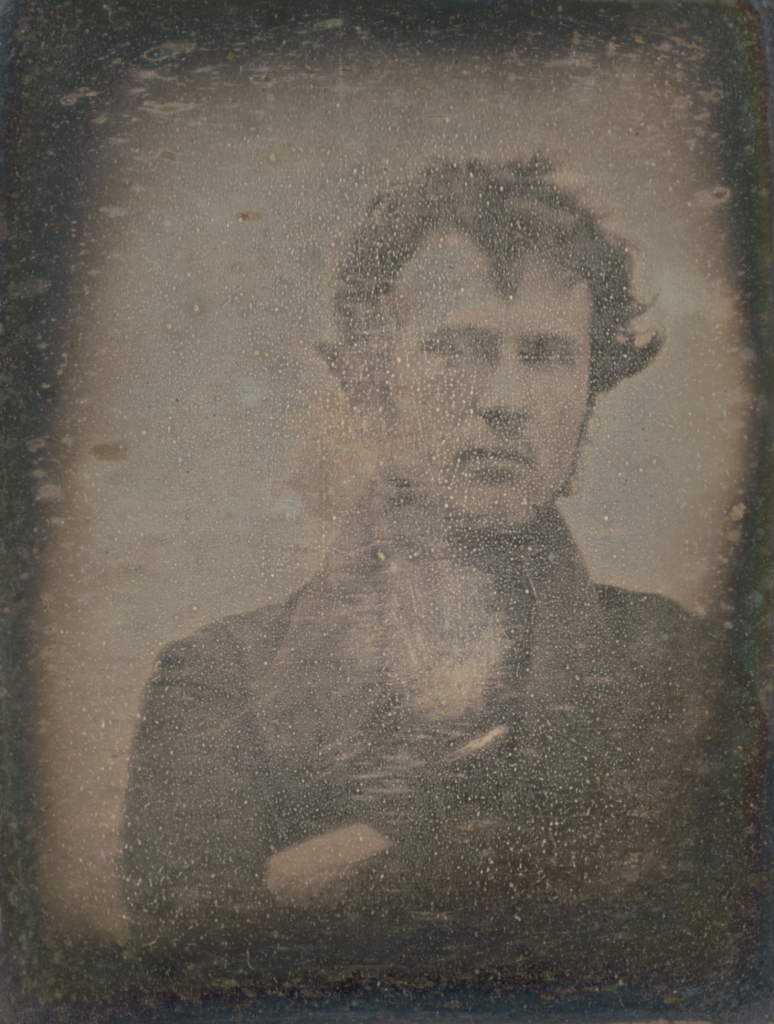 The first self-portrait in photography history shows Robert Cornelius. In this portrait, he has a serious expression.